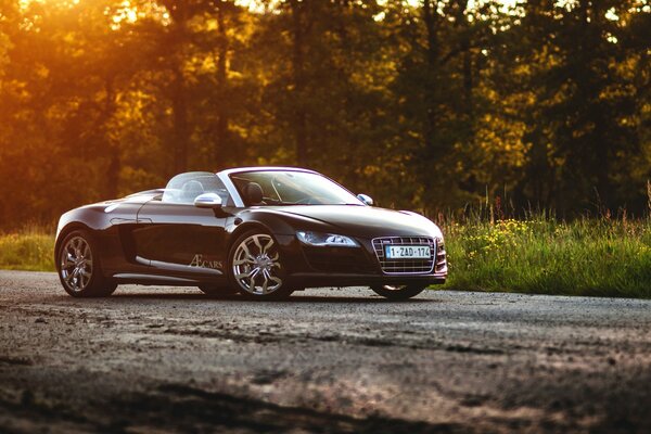 Audi R8 V10 spyder nero sullo sfondo del tramonto