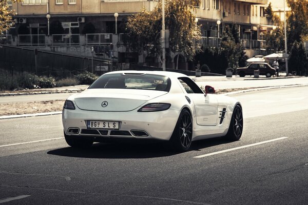 A white German Mercedes car is on the road