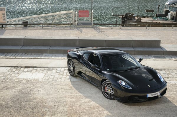 Black supercar on the embankment top view