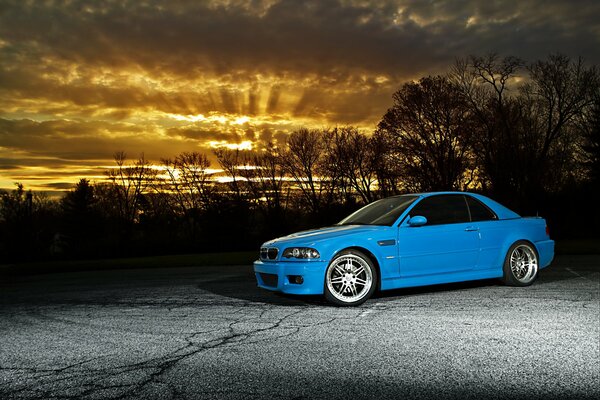 BMW bleu sur fond de coucher de soleil
