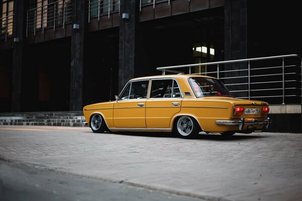 Low yellow Lada at the building