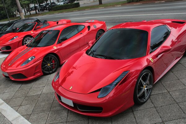 Ferrari 458 spider supercars in red are parked by the road