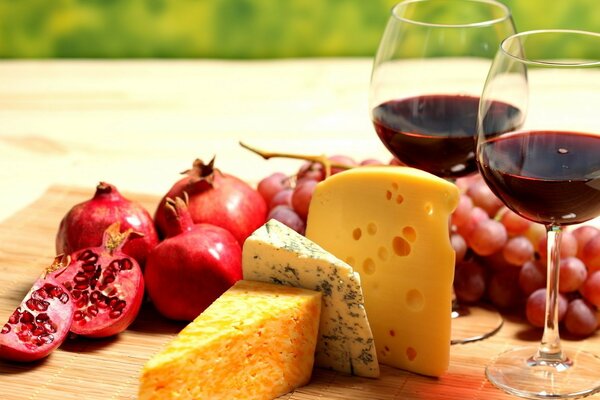 Zwei Gläser Wein mit Käse, Trauben und Granatapfel