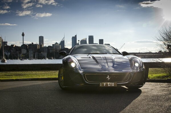 Black Ferrari car on the background of skyscrapers