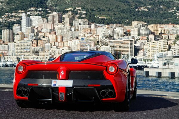 Roter Ferrari vor dem Hintergrund der Großstadt