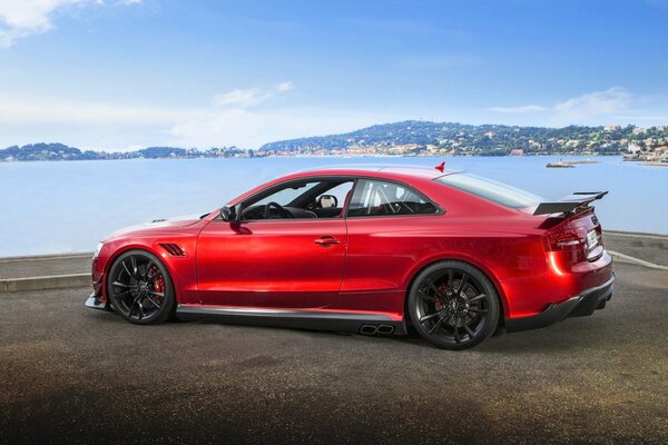 Audi red on the background of water near the shore