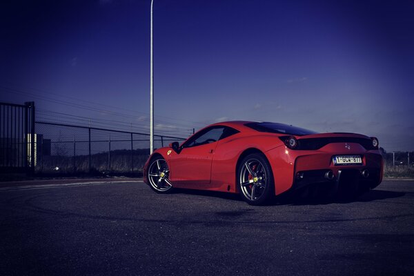 Ferrari italiano rojo en la carretera por la noche