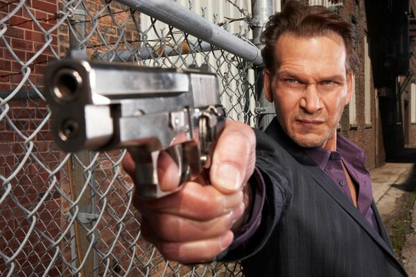 Attore Patrick Swayze con una pistola