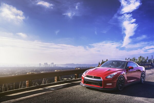 Red nissan gt-r on the horizon of the metropolis