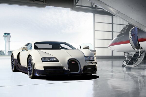 Bugatti and the plane in the hangar of the airfield