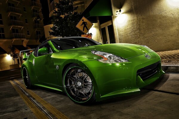 Bright green sports Nissan in the light of lanterns