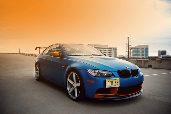 Bei Sonnenuntergang fährt ein unterschätzter BMW in Blau