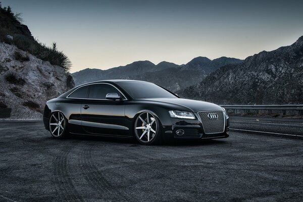 Audi noir au milieu des collines sur la route