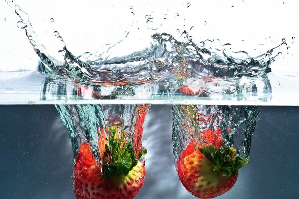 Fresas cayendo en el agua con salpicaduras