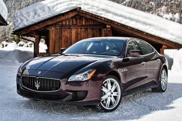 El coche italiano maserati en el fondo de un granero en el invierno