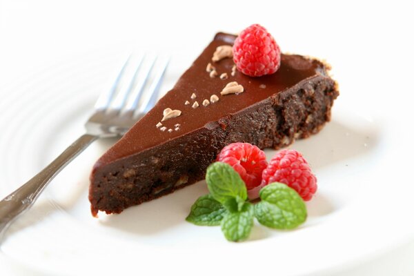 Pedazo de pastel de chocolate adornado con una baya