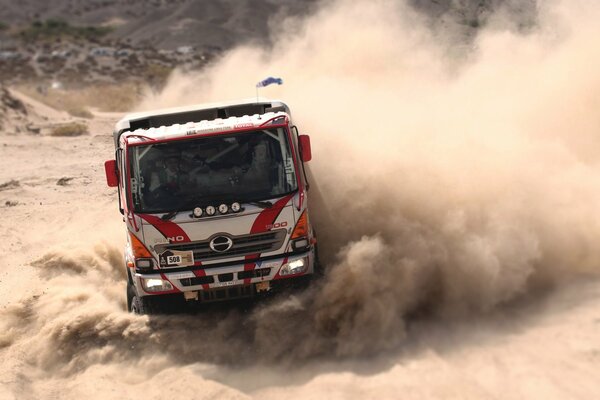 Camion sportivo che polverizza sulla pista sulla sabbia