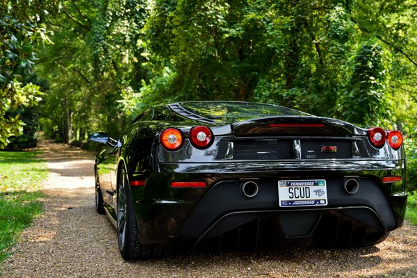 Scuderia Ferrari F430 nera su uno sfondo di alberi