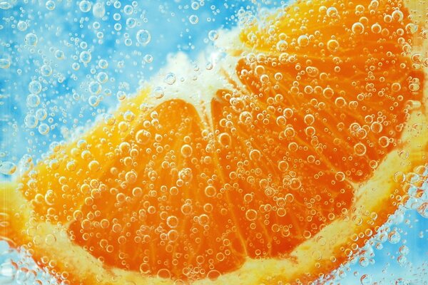 Eine Orangenscheibe unter Wasser in Blasen