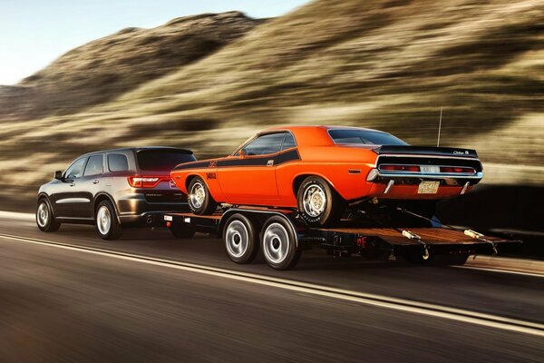 Challenger drags a mustang on a trailer