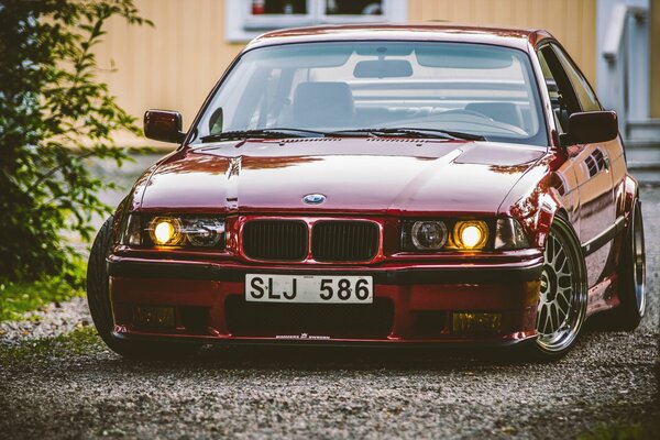 Roter getunter BMW im Schatten mit Zahlen