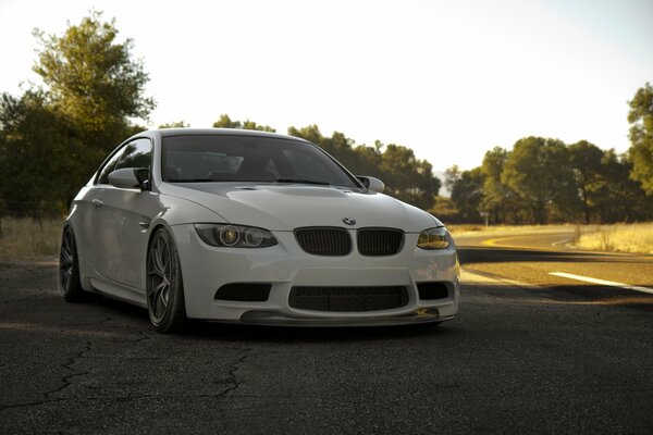 Weißer BMW steht auf asphaltierter Straße