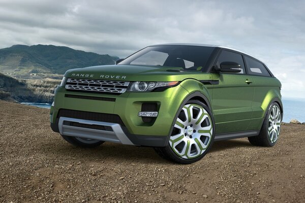 Grünes Auto Land Rover auf Himmel und Berg Hintergrund