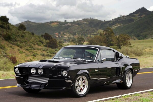 Ford Mustang noir sur fond de montagnes