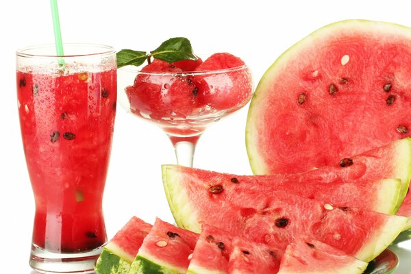 Sliced watermelon and juice from it in a glass with a straw