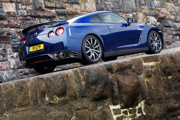 Voiture bleue nissan sur route de montagne