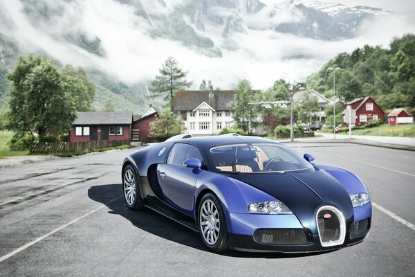 A supercar in an urban environment. Houses and mountains