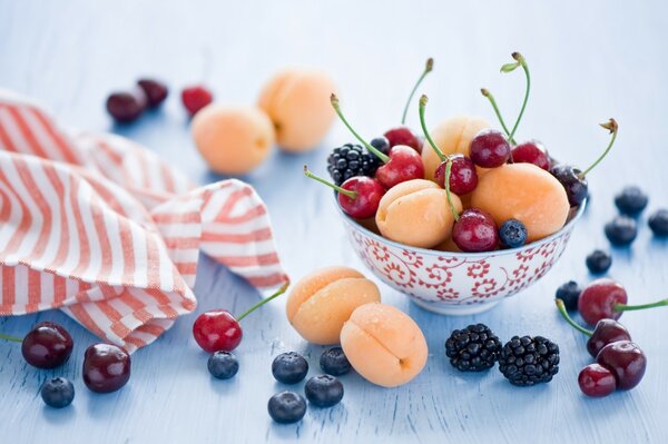 Beeren und Früchte in einer Tasse stehen auf dem Tisch