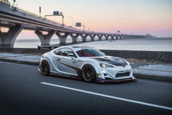 A tuned car on the road under the bridge