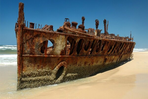 Vecchia nave arrugginita sulla spiaggia