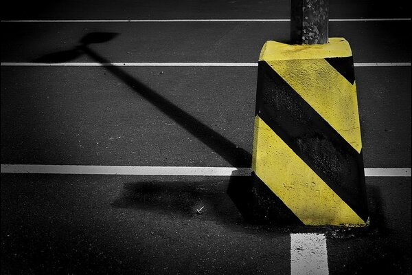 Straßenpfosten mit schwarzen und gelben Linien
