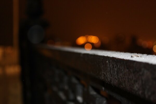 A muddy image of the railing, where lights are burning on the background