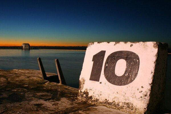 A picture with a number on a stone at sunset