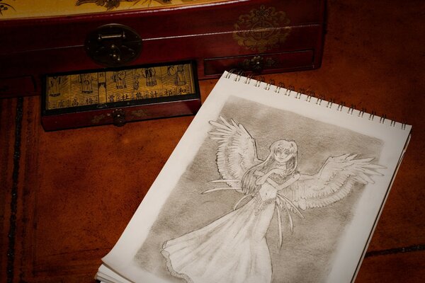 An angel with wings drawn in a notebook