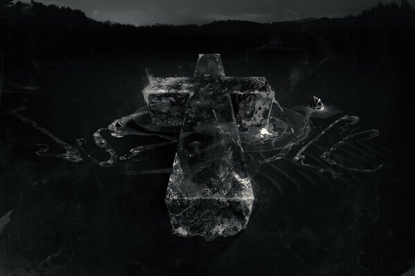 A black and white cross made as if of granite on a dark background and slightly illuminated