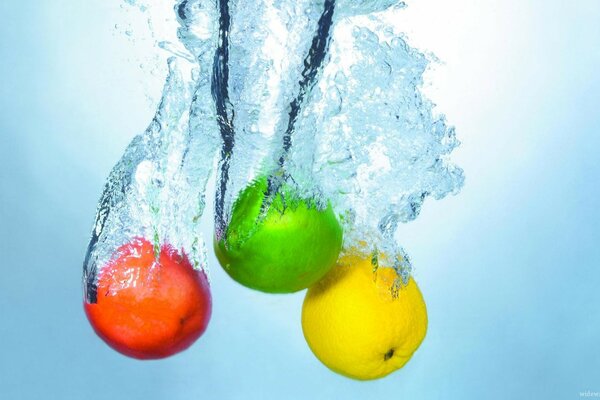 Trois pommes multicolores plongent dans l eau