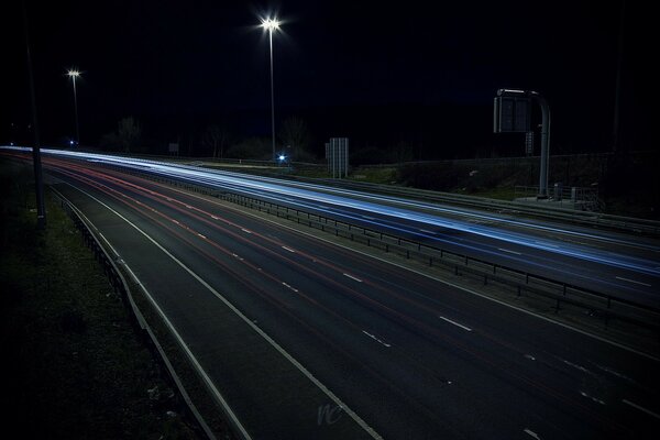 The night, empty road shines with lights