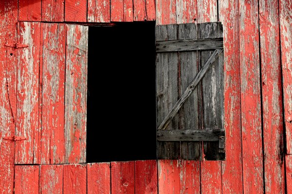 A window made of red planks of an old barn