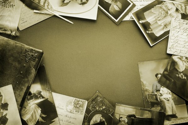 На столе лежат старые фотографии в чёрно-белом цвете
