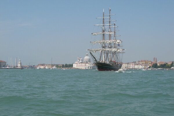 Sailing ship on the background of an Italian city