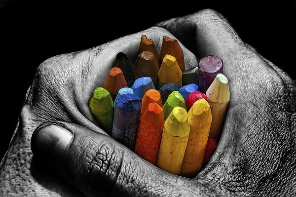 Gray hands holding colored pencils