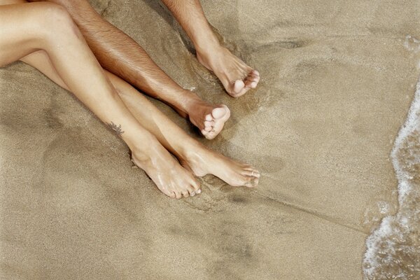 Hombres y mujeres pies en la playa