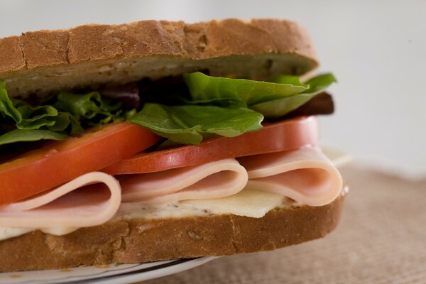 Delicioso sándwich con lechuga, tomate y jamón