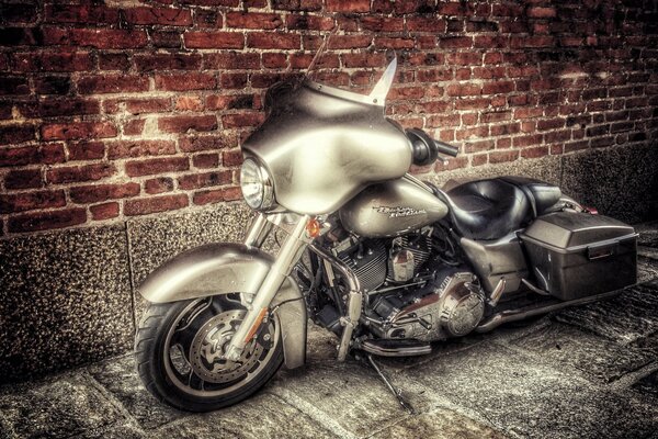 Die legendäre Harley ist ein ungewöhnliches Motorradmodell vor dem Hintergrund einer Backsteinmauer