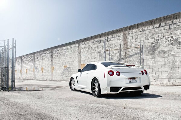 Nissan blanco contra una pared gris