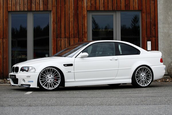 White BMW on asphalt against the background of large windows